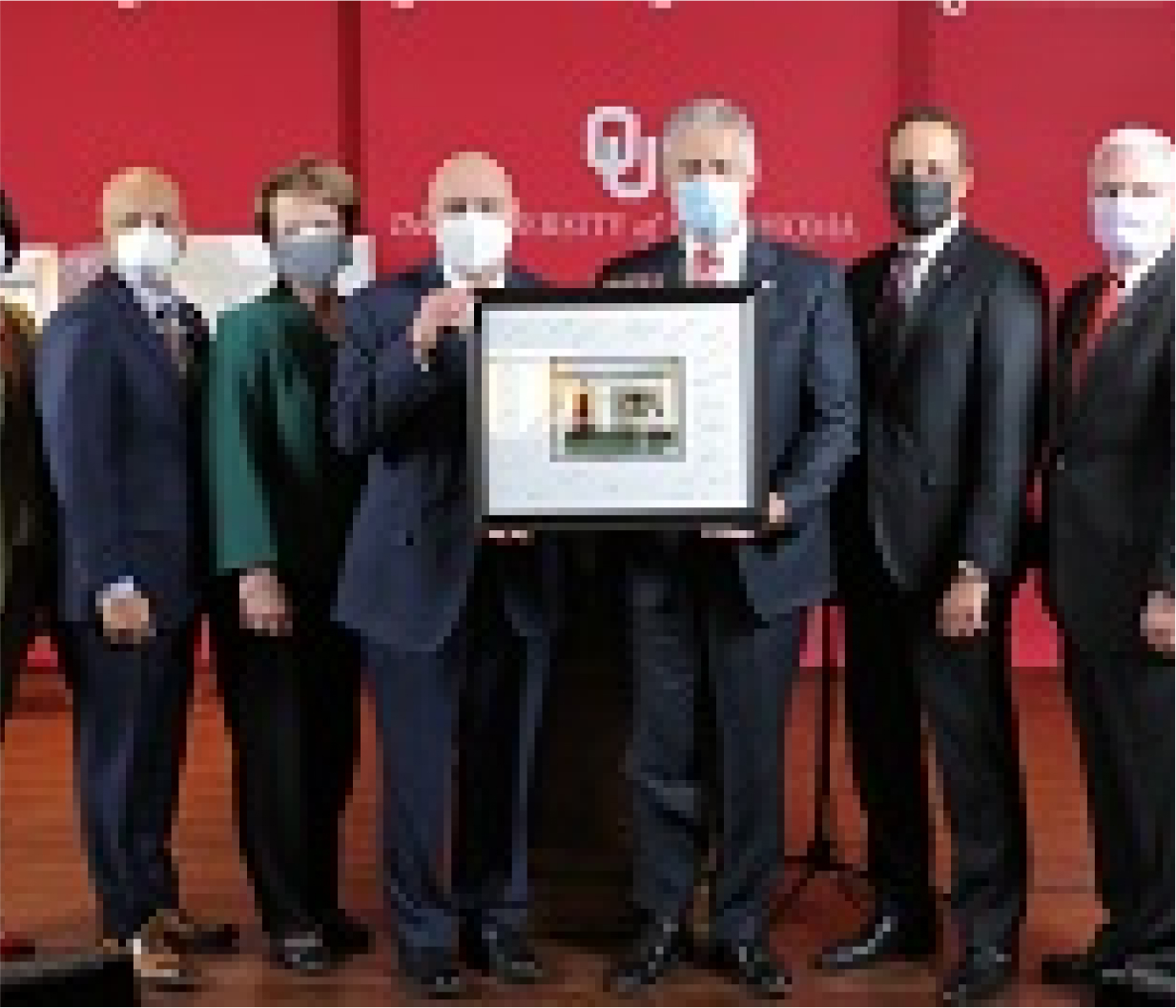 Group of people in suits presenting a scholarship at OU